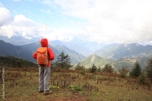 young determined woman backpacker hiking on mountain peak © lzf