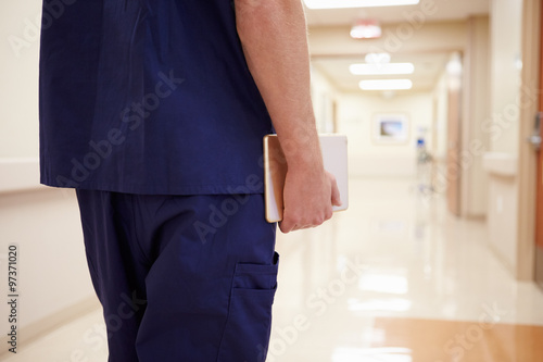 Close Up Of Nurse With Digital Tablet In Hospital Corridor