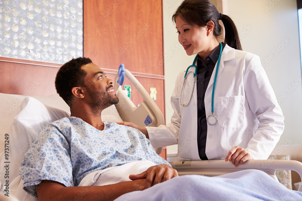 Female Doctor Talking To Male Patient In Hospital Bed Female Doctor Talking To Male Patient In Hospital Bed