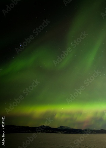 Northern Lights dancing over frozen Lake Laberge Yukon Canada