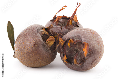 Three fresh organic medlars, isolated on white background