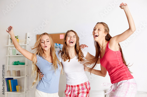 happy friends or teen girls having fun at home photo