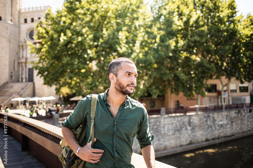 Handsome bearded man standing on bridge and looking away Handsome bearded man standing on bridge and looking away