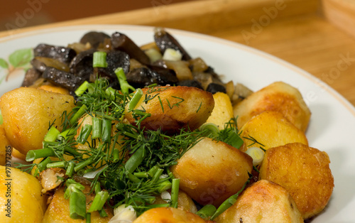 potatoes and fried mushrooms wood background