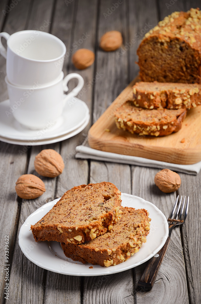 Banana bread with walnuts on the rustic wooden background