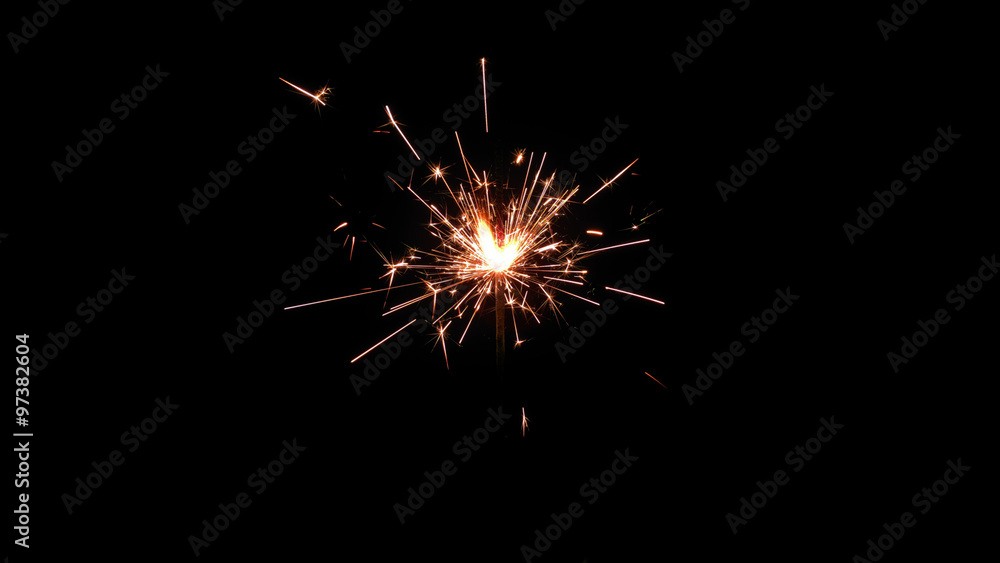 Centrally positioned firework sparkler burning isolated. Gun powder sparks shot against deep dark background
