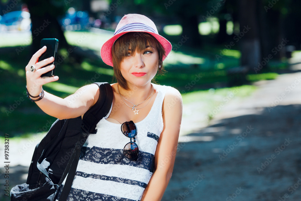Young woman, making selfie with smart phone. In park