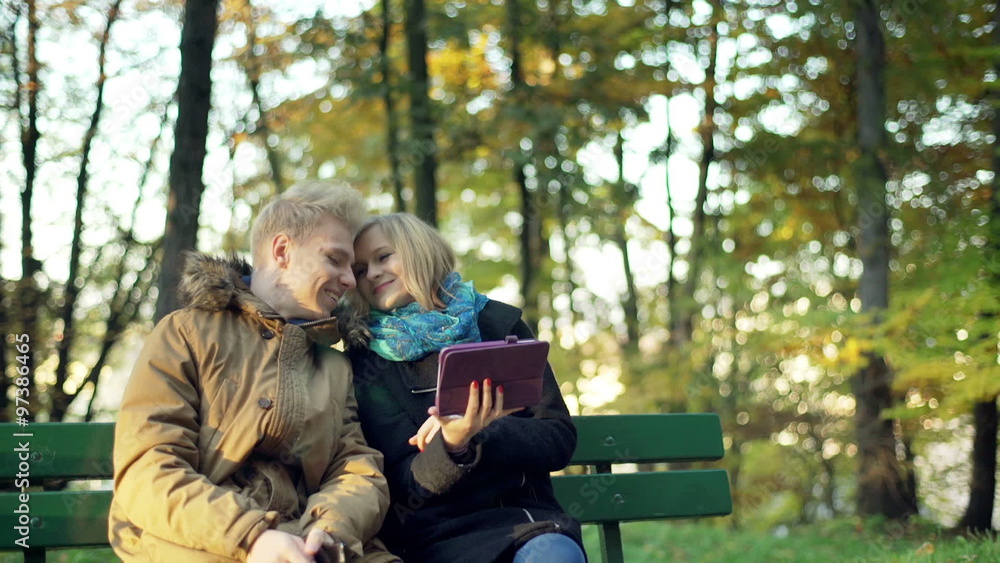 Couple browsing internet on tablet in the autumnal park
Couple browsing internet on tablet in the autumnal park