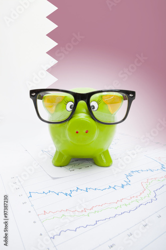 Piggy bank with flag on background - Qatar photo