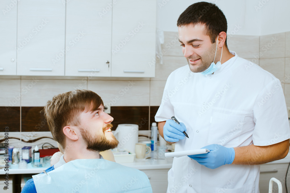 Obraz premium dentist taking notes with happy patient