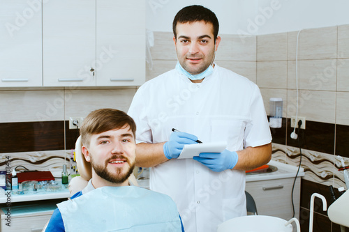 dentist with notebook and happy patient