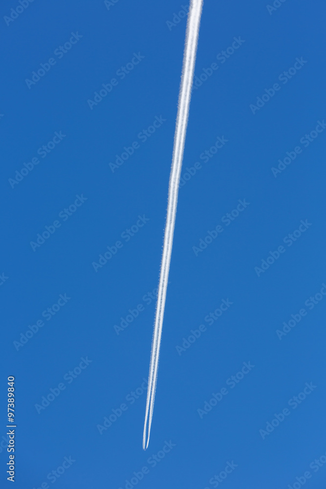 Fototapeta premium Airplanes leaving diagonal trace on a clear blue sky.