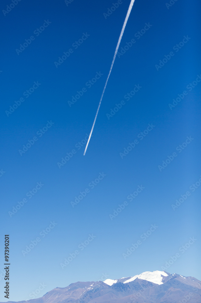 Closeup on airplane contrail against clear blue sky with the Aco