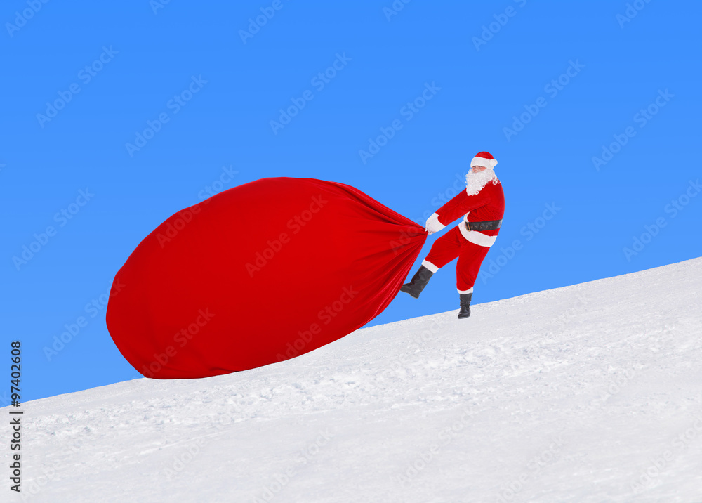 Santa Claus pull large Christmas bag against snowy winter landscape