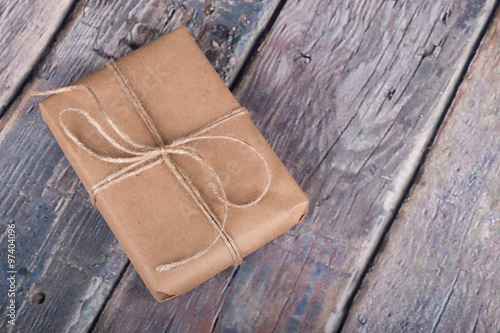 Gift Wrapped in Brown Paper on a Rustic Wooden Surface