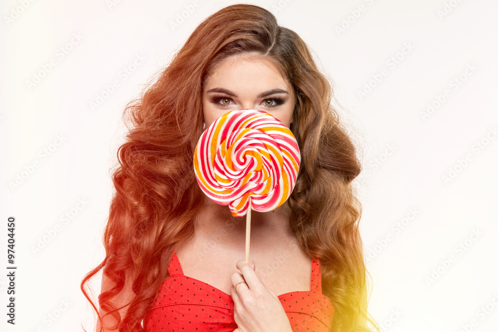 Portrait of a smiling cute girl covering her eye with lollipop