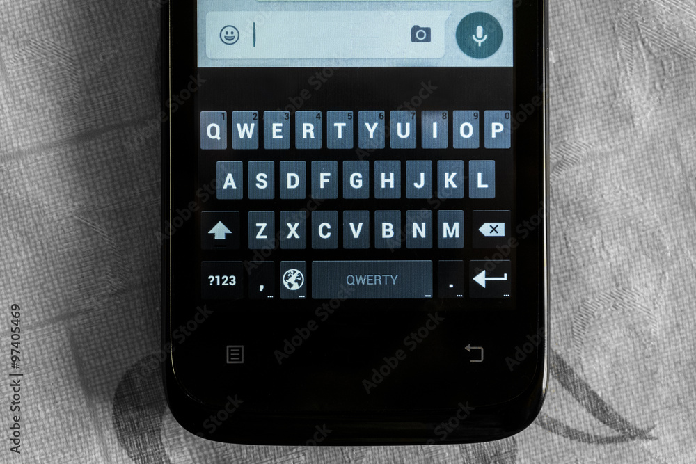 Obraz premium Smartphone. The touch keyboard smartphone on the background of the surface discolored.
