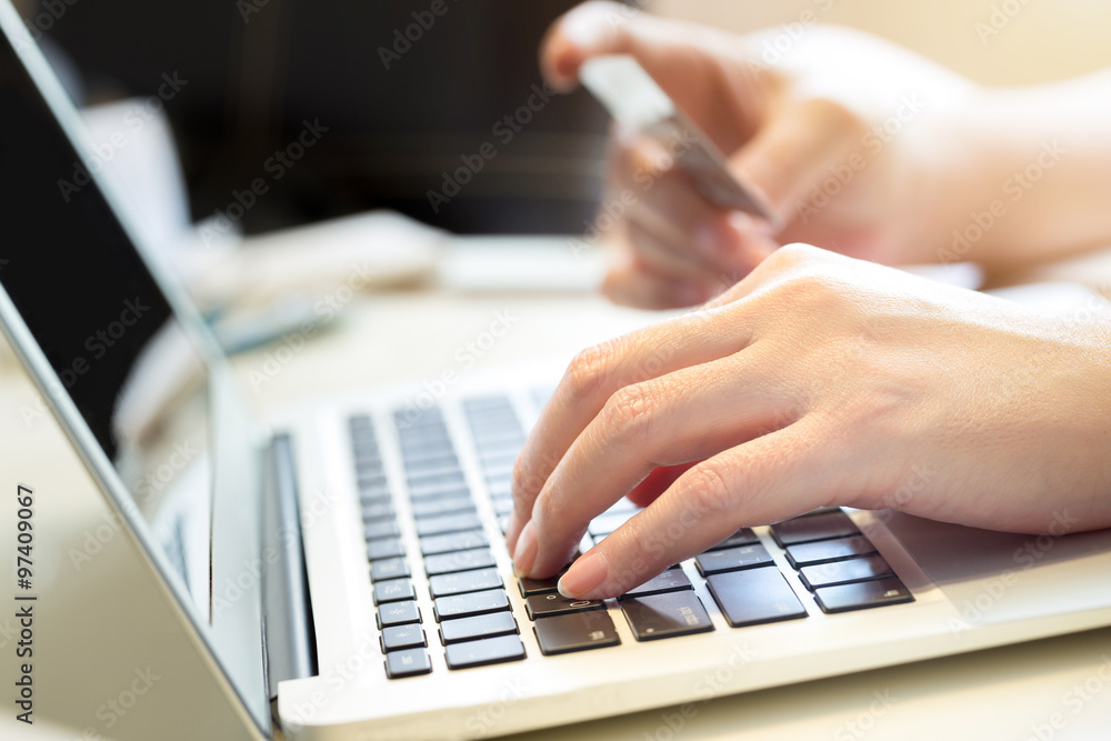 woman holding credit card on laptop for online shopping concept woman holding credit card on laptop for online shopping concept