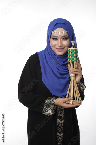 Malaysian malay woman holding a traditional oil lamp for eid isolated in white
