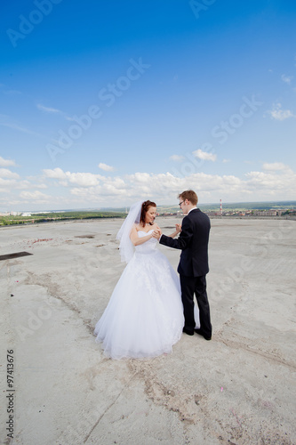 luxury romantic gorgeous holding hands bride and groom on the background of old sunny city