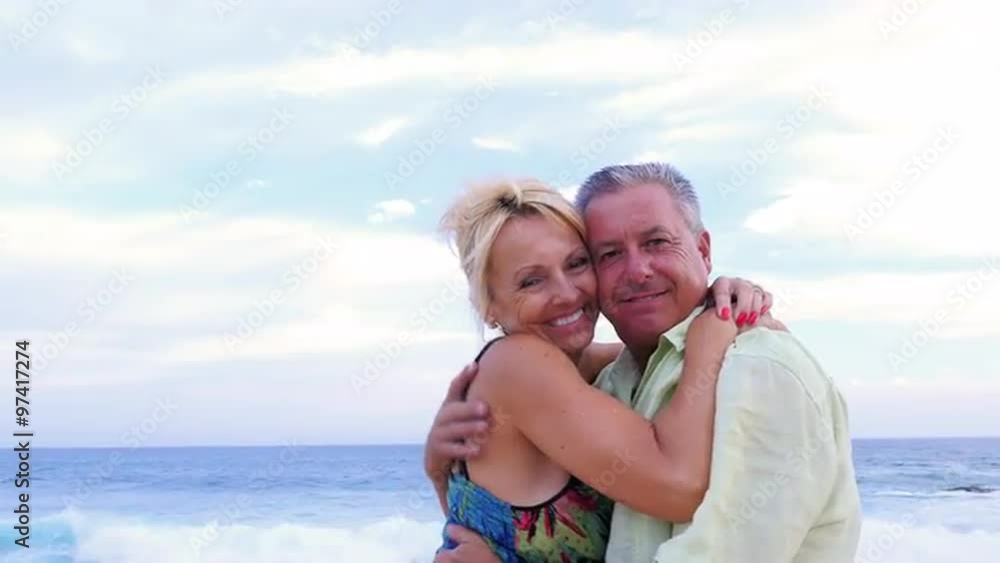 Portrait of an older couple hugging and smiling at the beach Portrait of an older couple hugging and smiling at the beach