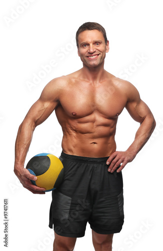 Smiling shirtless bodybuilder posing with valleyball.