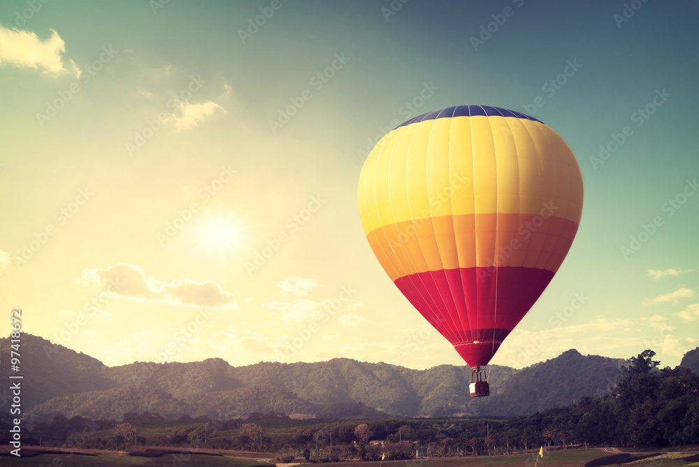 Hot air balloon over mountain, vintage retro filter effect