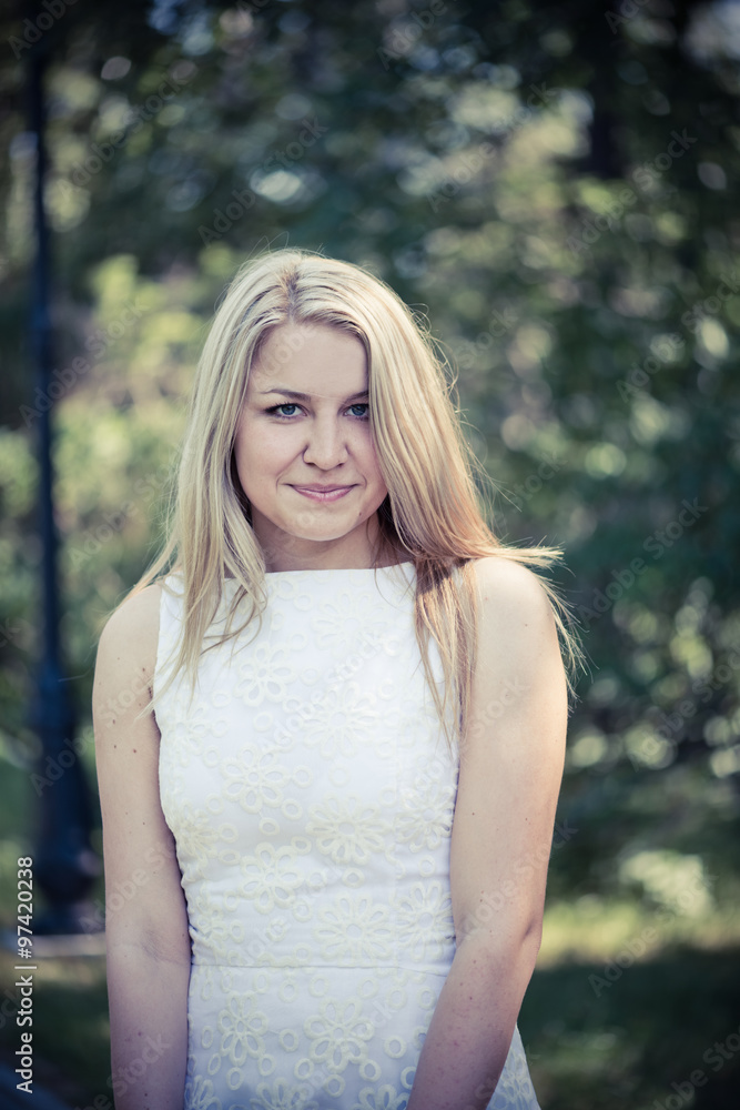Beautiful young blond woman in a white dress outdoors Beautiful young blond woman in a white dress outdoors