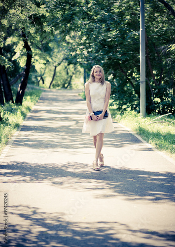 Beautiful young blond woman in a white dress outdoors © Valeri Luzina