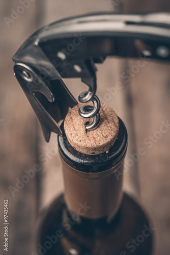 Cork screw and wine bottleOpening a wine bottle with a corkscrew in a restaurant