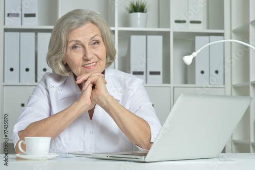 Elderly woman working on laptop