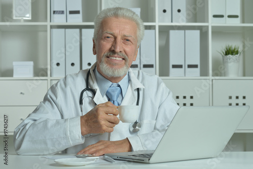 Elderly doctor with laptop