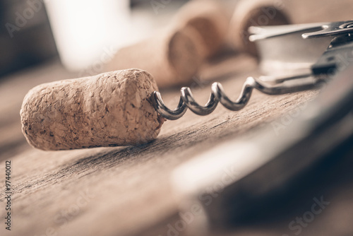Wine cork and corkscrew on wooden table photo