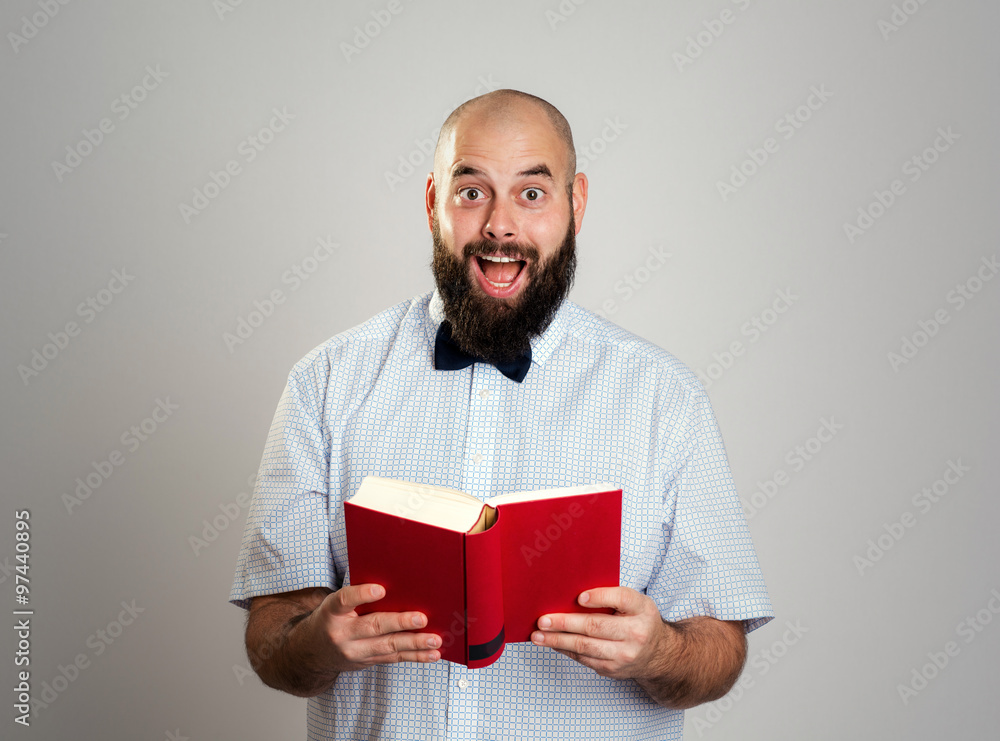 bearded man reading a book in front of gray background bearded man reading a book in front of gray background