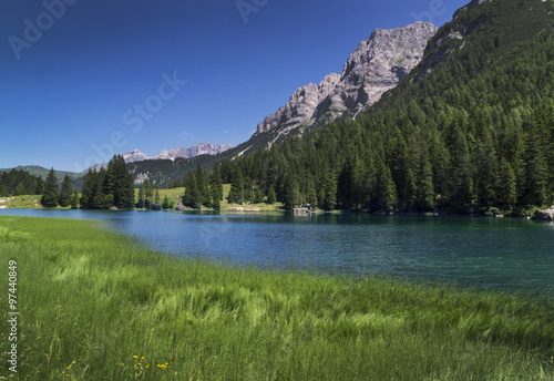 Gebirgssee Lago Agola in den Alpen,Italien, grünes Gras 