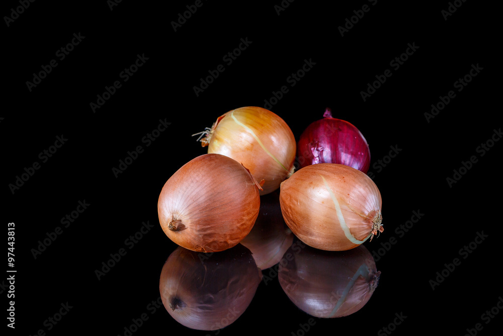 Onion and red onion reflected in a black mirror