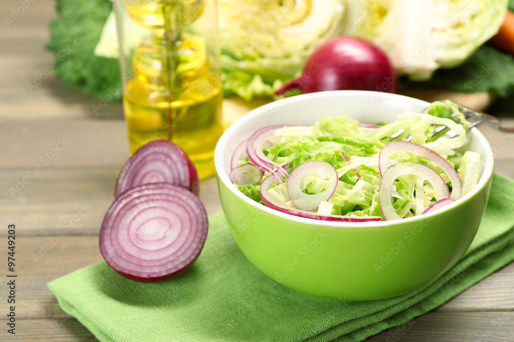 Savoy cabbage and onion salad served in bowl on wooden table Savoy cabbage and onion salad served in bowl on wooden table