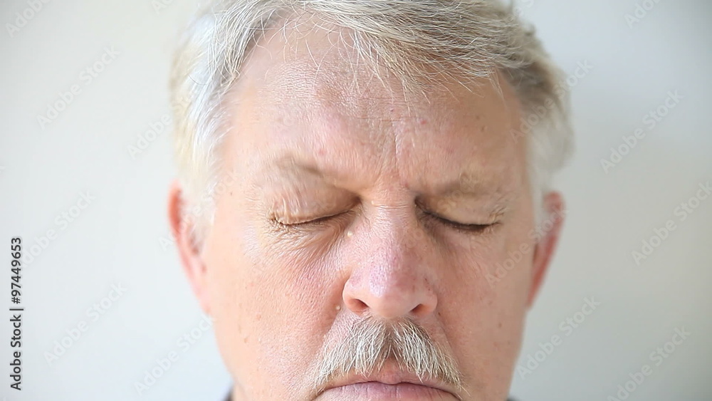 Senior man tries to clear his vision. Senior man tries to clear his vision.