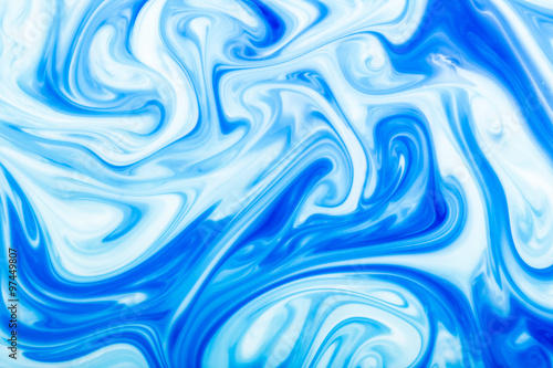 Blue ink flowing in milk texture.