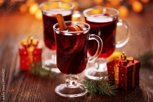 Mulled wine with gifts on wooden table
