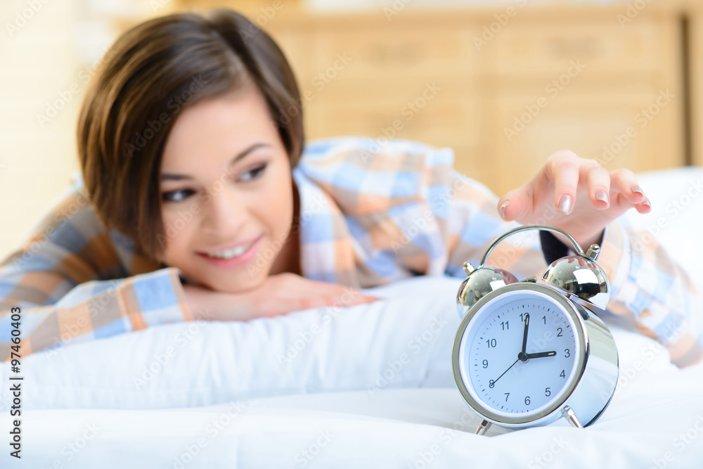 Young girl touching the alarm clock. Young girl touching the alarm clock.