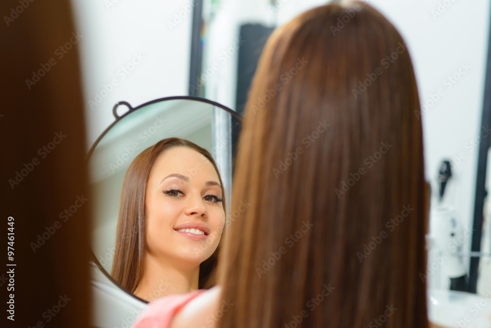 Client is admiring her new hairdo. Client is admiring her new hairdo.