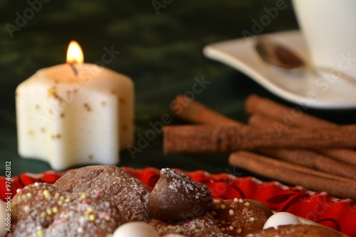 Lovely close up image of Christmas cookies on a decorated table with lighted candles