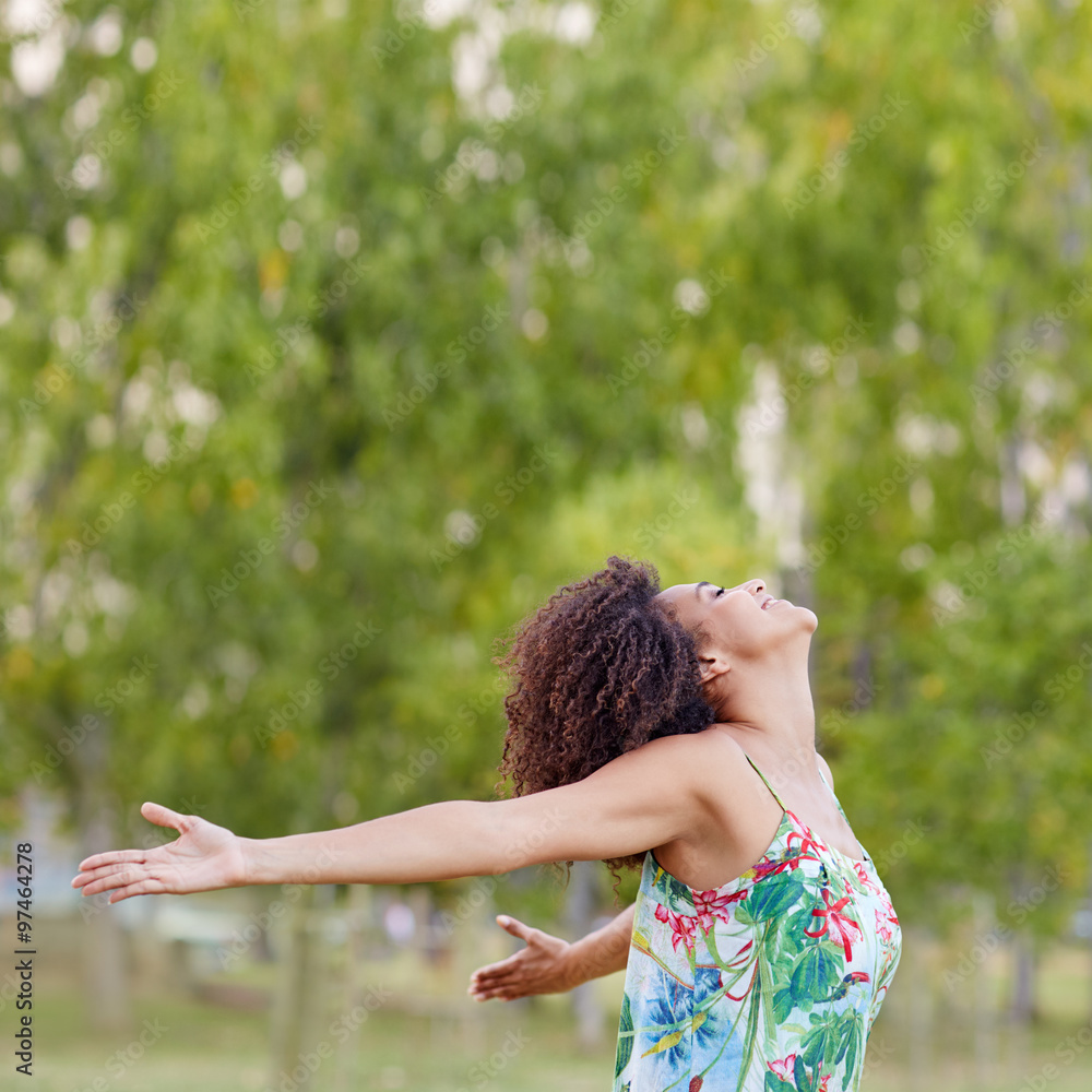 Woman with an afro hairstyle feeling free in a park Woman with an afro hairstyle feeling free in a park
