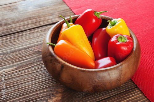 Colorful bell pepper in a wooden bowl on the table