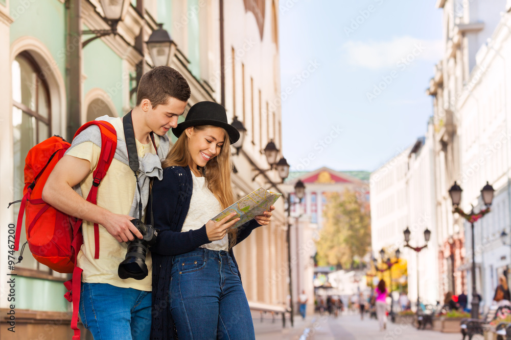 Young man and girl as two tourists with city map