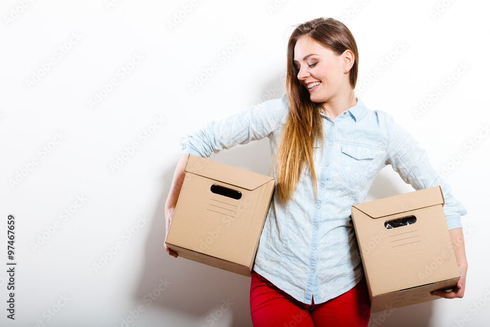Happy woman moving into house carrying boxes. Happy woman moving into house carrying boxes.