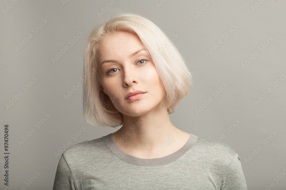 Naklejka premium bliska portret młodej pięknej kobiety blondynka na szarym tle