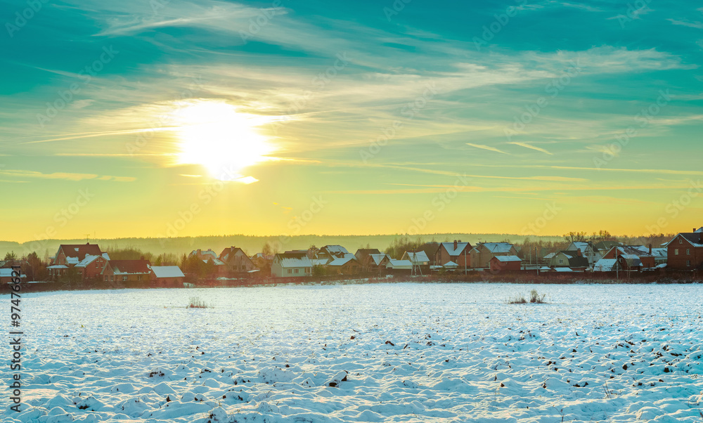 Obraz premium Winter landscape: field, houses, sunset