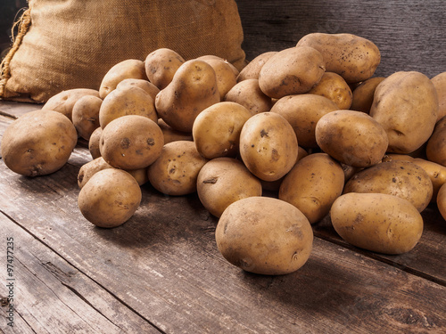 Canvas Print Potatoes From Bag Lying On Wooden Boards